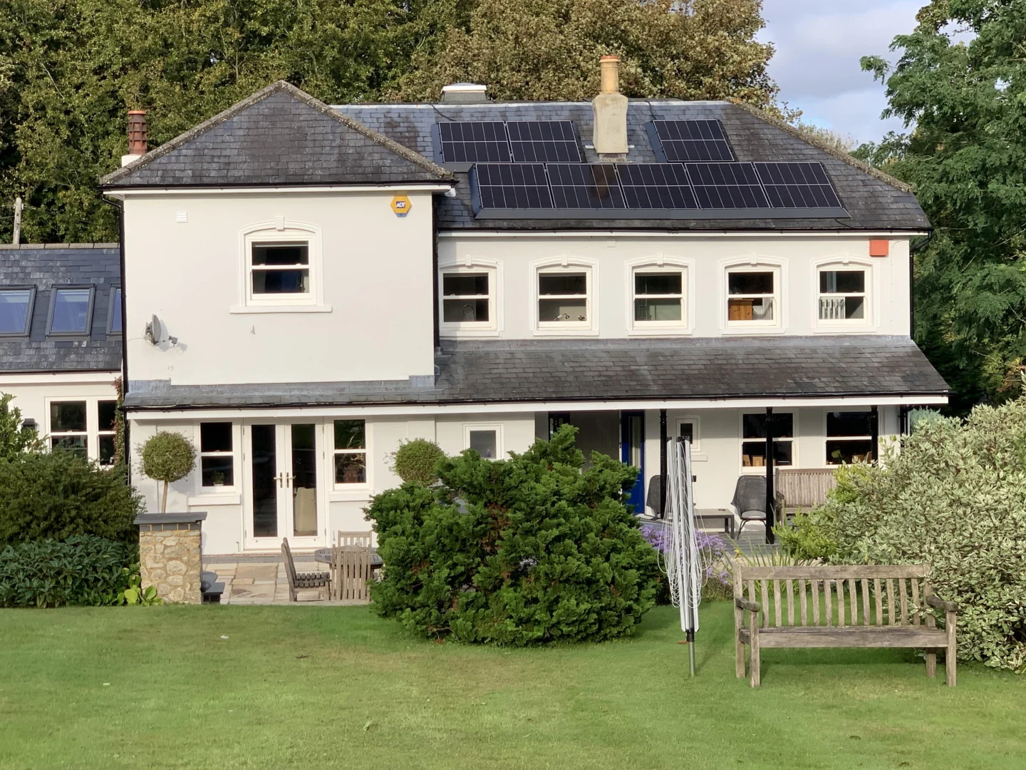 Rear view of residential home with solar panels on multiple roofs