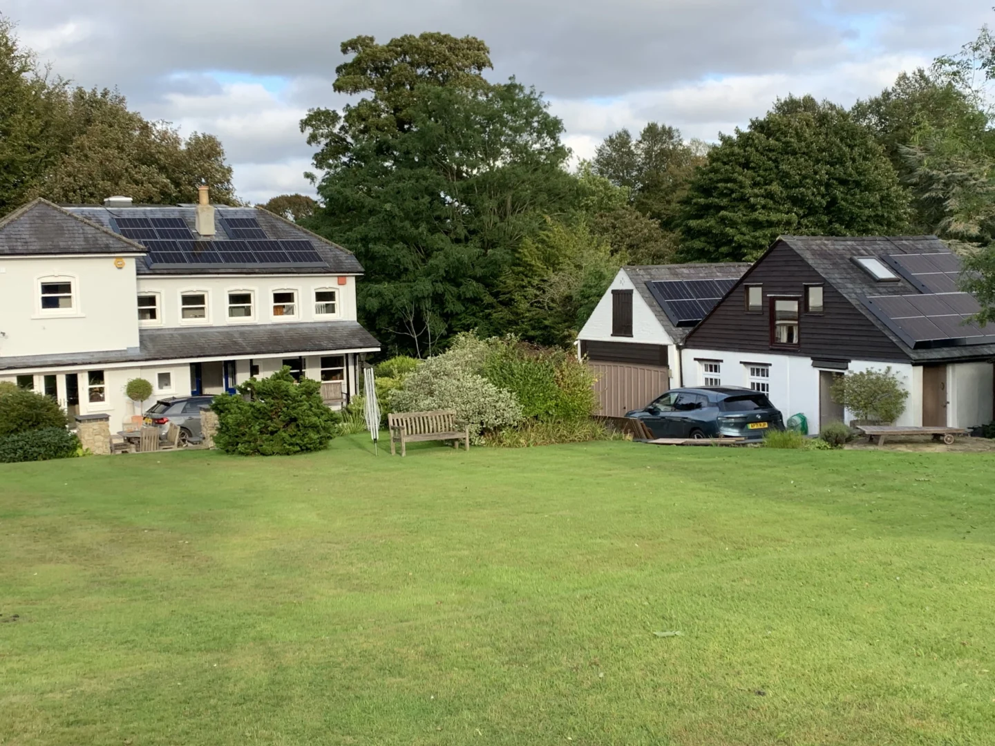 Rear view of residential home with solar panels on multiple roofs