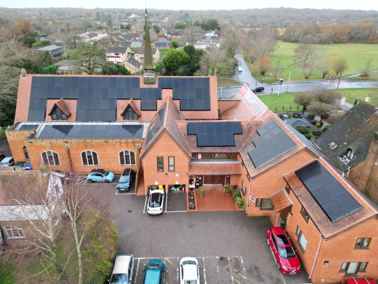 Aerial view of solar panels on multiple roofs of St George’s Church, Surrey