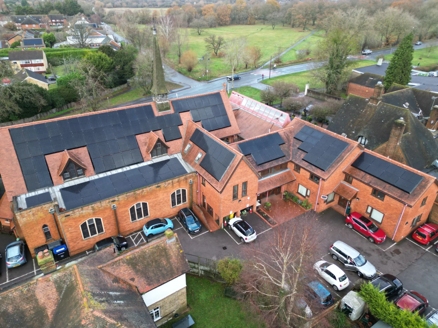 Aerial view of solar panels on multiple roofs of St George’s Church, Surrey