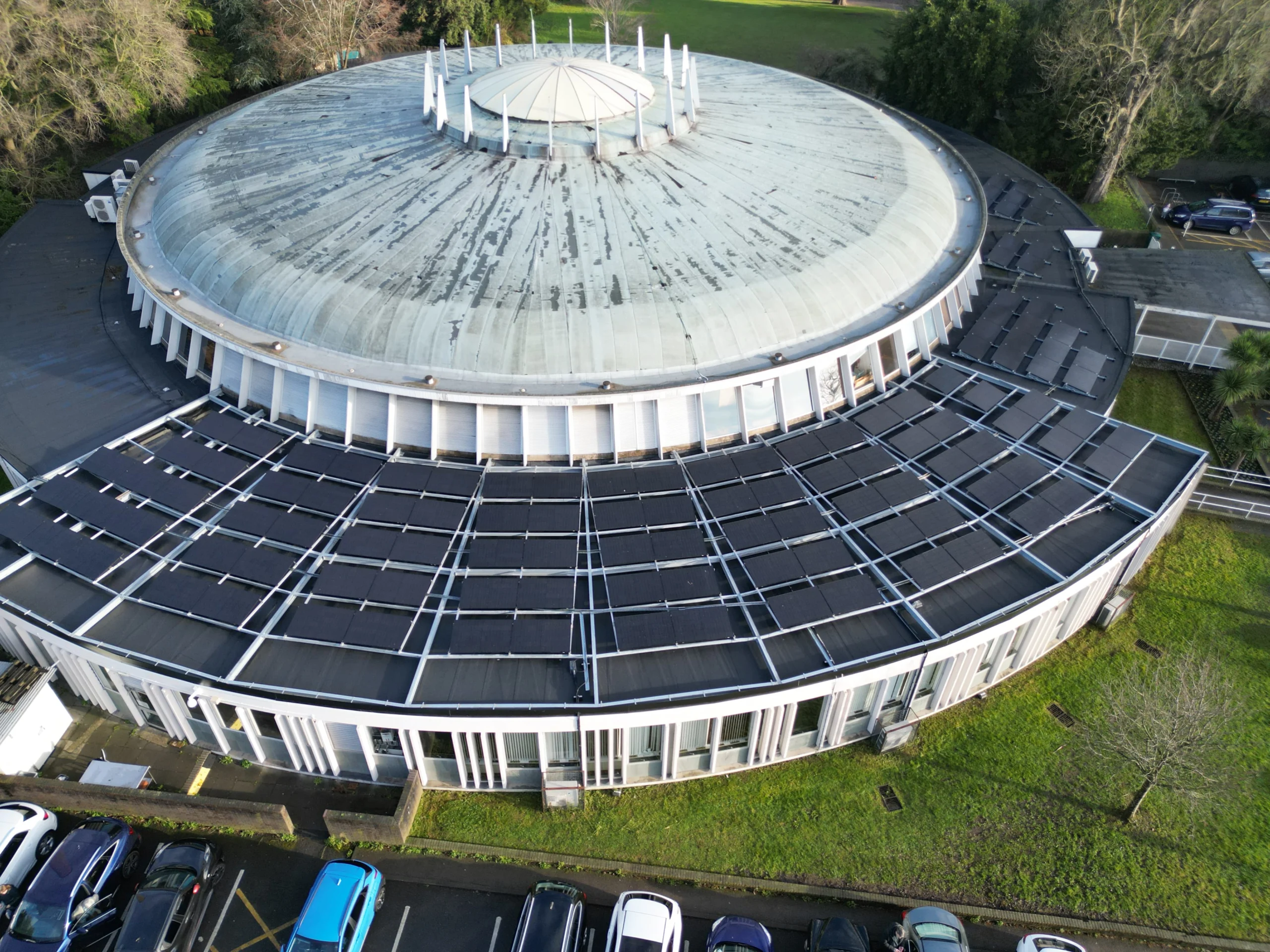 Solar panel installation on Bourne Hall's roof, featuring 116 black bifacial DMEGC 450W panels mounted on a custom steel structure for maximum energy efficiency
